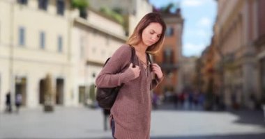 Kadınlar yol tarifi için akıllı telefondan harita kullanarak Roma caddesinde yürürler. Sırt çantasıyla cep telefonu kullanan çekici bir kadın. 4k