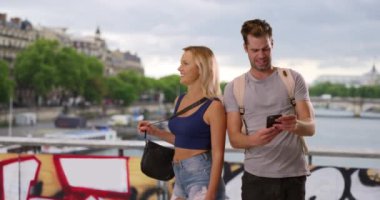 Paris 'te yol tarifi için akıllı telefonu kullanan mutlu bir çift. Kayıp Kafkas erkek ve kadın cep telefonunda harita kullanıyor. 4k