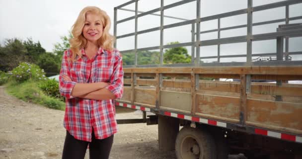 快乐的白人女人站在农场的卡车旁 对着摄像机微笑 迷人的女人穿着法兰绒衬衫 摆出卡车的姿势 为自己是农民而自豪 — 图库视频影像