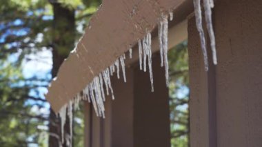 Dışarıdaki çatının kenarındaki buz saçakları eridi. Kabinin çatısındaki eriyen buzun yakın görüntüsü ilkbaharın başlarında pervazlanıyor.