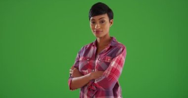 Güzel bir evin ön bahçesinde duran, yeşil ekranda kameraya gülümseyen sevimli siyah kadın. Anahtar ya da birleşik olmak üzere yeşil ekranda.