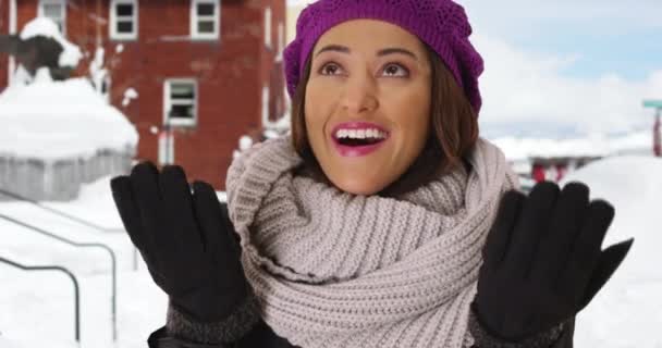 一个快乐的拉丁女人站在外面的雪地里 在多雪的小镇上 一个兴奋的年轻女子伸出双手去捕捉雪花的画像 — 图库视频影像