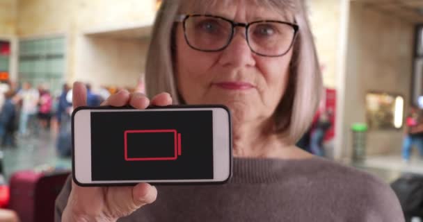 Gammal Kvinna Tågstationen Håller Telefonen Med Låg Batteriindikator Blinkar Kaukasiska — Stockvideo