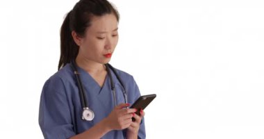 Taklit uzay için akıllı telefonlu mesajlar okuyan ciddi bir bin yıllık doktor. Önlük giyen genç kadın hemşireyi kapatın ve beyaz arka planda izole edilmiş mobil cihazlar kullanarak mesajlar yollayın. 4k