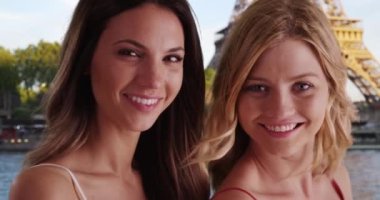 Seine Nehri 'nin kıyısında kameraya poz veren iki güzel kadın. Eyfel Kulesi 'nin önünde kameraya gülümseyen güzel beyaz kızların portresi. 4k