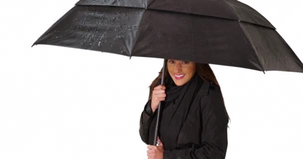 スタジオで黒い傘を持ってかわいいラティーナ女性の肖像画 陽気な若い女性が傘の下で避難所を取って カメラで笑っている — ストック動画
