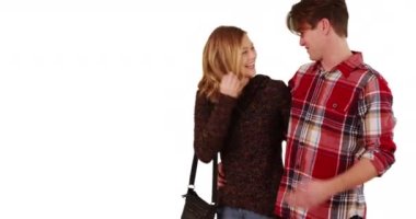 Kameranın karşısında yürüyen genç bir çift, beyaz arka planda kollarını birbirine dolamış, kopyalanmış bir şekilde. Erkek ve kadın birbirlerinin gözlerinin içine bakıp stüdyoda fotokopi çekiyorlar. 4k