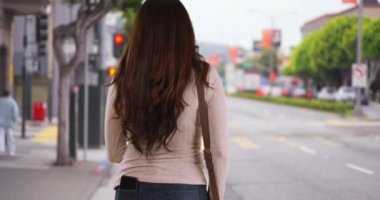 İspanyol kadın yaya geçidinde sabırsız bir şekilde binmek için bekliyor. Latin bir kadın, kenar mahallede elleri kalçalarında, hayal kırıklığına uğramış bir şekilde etrafa bakıyor. 4k