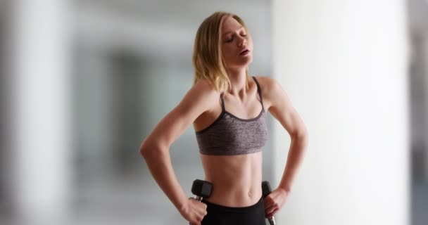 适合年轻的金发千禧年女子在健身房举重后休息 健身中心的妇女从力量训练中休息 — 图库视频影像