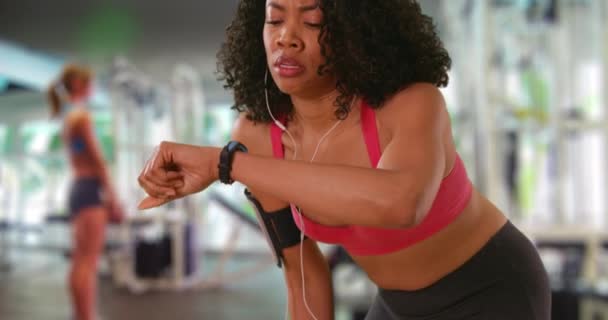 Ganska Afroamerikansk Kvinna Trött Efter Träning Gymmet Kollar Smart Klocka — Stockvideo