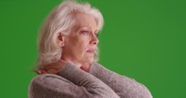 緑色の画面に首の痛みを伴う高齢女性のクローズアップ 緑の画面上の慢性首の痛みを持つ彼女の50代の成熟した女性のクローズアップは キーまたは構成される — ストック動画