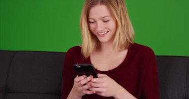 Zeki yirmili yaşlarda bir kadın yeşil ekranda cep telefonuyla mesajlaşıyor. Anahtar ya da birleşik olmak üzere yeşil ekranda.