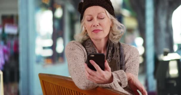 Starší Žena Sedící Lavičce Před Obchodem Dívající Zmateně Mobil Atraktivní — Stock video