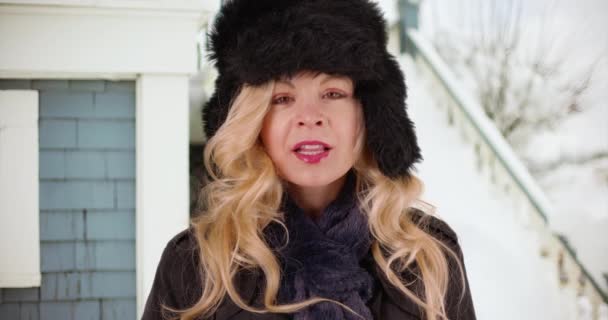 Веселая Белая Женщина Уютной Шляпе Шарфе Стоящая Снаружи Дома Снегу — стоковое видео
