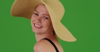 Güneş şapkalı, yeşil ekranda gülümseyen beyaz kadın. Anahtar ya da birleşik olmak üzere yeşil ekranda.