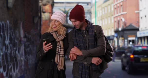 伦敦的失恋夫妇在智能手机上使用地图 白人男性和女性在手机上使用应用程序来获取方向 — 图库视频影像