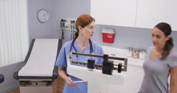 환자의 몸무게를 중년의 침엽수 간호사 라티나 환자의 몸무게를 측정하기 체중을 — 비디오