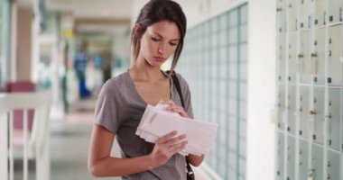 Genç beyaz kadın postanedeyken aldığı mektuplara bakıyor. Beyaz bin yıllık kadın postane koridorunda mektup yığınını kontrol ediyor. 4k