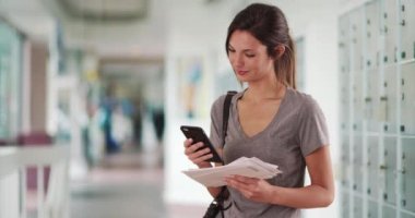 Mektupları olan bir kadın akıllı telefonu kontrol ediyor ve postanede ekranın dışında yürüyor. Milenyum Kafkas 'lı kız, ellerinde kolilerle telefonla mesajlaşan mektuplar tutuyor. 4k