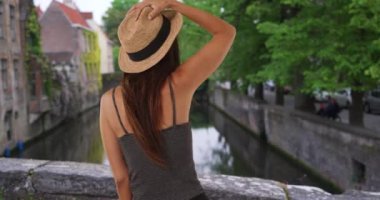 Brüj 'de tatilde olan sevimli bir milenyum kızı neşeyle köprüde dönüyor. Kanal yakınlarında Avrupa 'ya seyahat eden neşeli ve heyecanlı bir turist kadın. 4k
