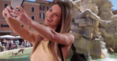 Mutlu milenyum kızları Roma 'daki Fiumi Çeşmesi' nin akıllı telefonuyla selfie çekiyor. 20 'li yaşlarda beyaz bir kadın Roma, İtalya' da telefonla fotoğraf çekiyor. 4k