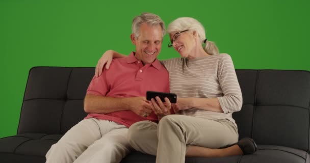 快乐的老年人坐在沙发上 在绿色屏幕上观看智能手机上的视频 在绿色屏幕上键入或合成 — 图库视频影像