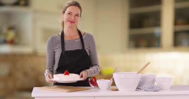Wesoła Biała Kobieta Prezentująca Ciasto Degustująca Lukier Palcem Współczesnej Kuchni — Wideo stockowe