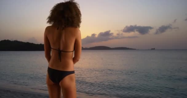 年轻的黑人妇女在落日海滩上穿着比基尼戏弄 — 图库视频影像