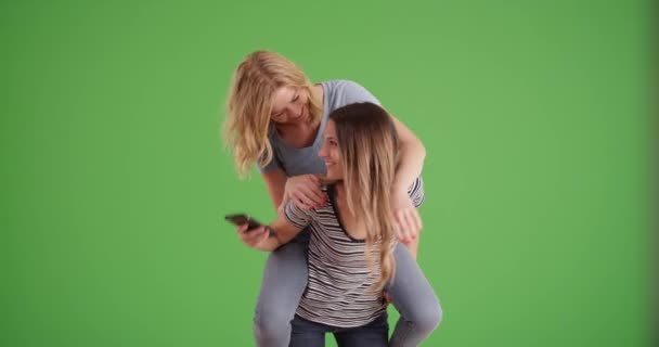 Two Funny Girls Fooling Piggy Back Taking Selfie Greenscreen Couple — Stock Video