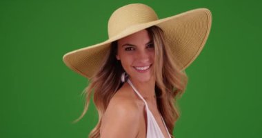 Yeşil ekranda sarkık şapkalı, bikinili genç beyaz kadın poz veriyor. Anahtar ya da birleşik olmak üzere yeşil ekranda.