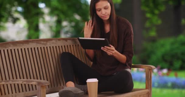 Millennial Vrouw Zit Parkbank Met Tablet Computer Het Drinken Van — Stockvideo