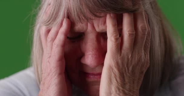 用绿色的色键让压力重重的老年妇女痛苦不堪 在绿屏前拍摄老年头痛偏头痛妇女的特写 — 图库视频影像