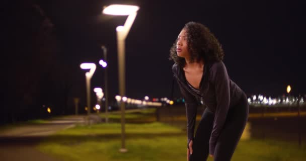 漂亮的非洲裔美国女人从夜间跑步穿过公园休息 女慢跑者从运动中休息 伸展腿 — 图库视频影像