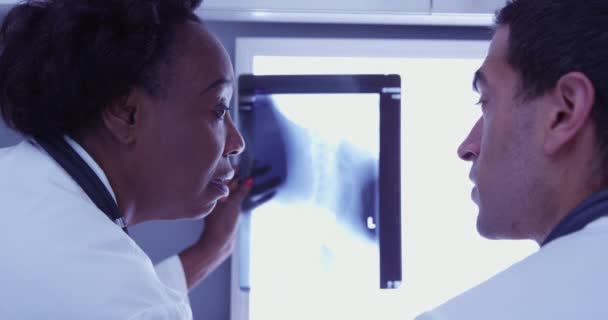 Close Médico Negro Meia Idade Revisando Radiografia Paciente Com Radiologista — Vídeo de Stock