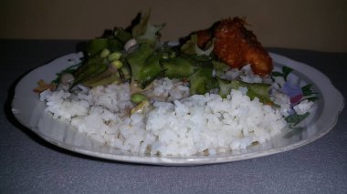 Yanında tavuk ve sebze tabağı olan basit bir yemek. Kızarmış tavuk ve sebzeli pilav. Tadı çok lezzetli. Basit yemek..