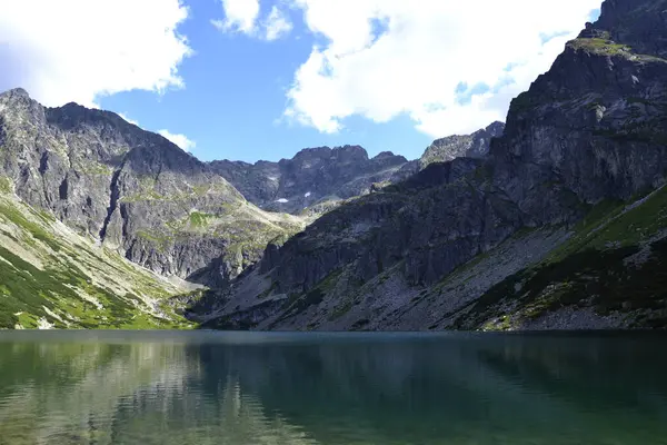 Dağlarda yeşil bir su gölü, bulutlu bir hava. Polonya 'nın Tatry kentinde Czarny staw gazienicowy gölü