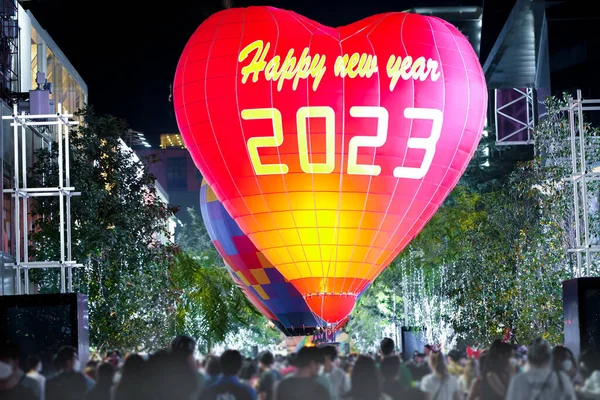 Organizing the New Year 2023 festival celebration. Write the word Happy New Year 2023 on the balloon.