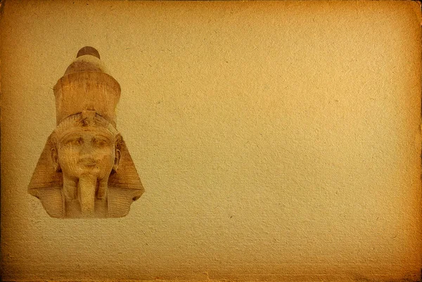 古代エジプトのファラオの顔の背景のクローズアップコピースペースと古い黄色の紙 — ストック写真