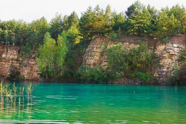Sarp kıyıları çayırlarla kaplanmış turkuaz bir göl.