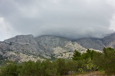 Dağ manzarası. Tepeleri bulutlarla kaplı yüksek dağlar