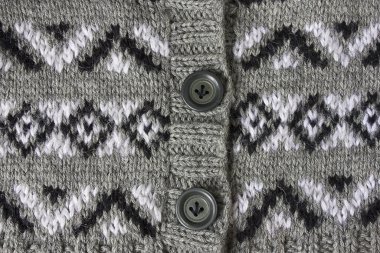 Şırıngalara örülmüş, yakın çekim Jacquard dokusu. Siyah beyaz yakut desenli ve düğmeli Cardigan