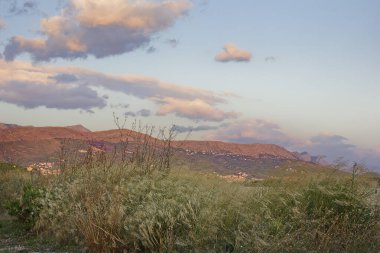 Dağlarla çevrili bir manzara. Akşam güneşinin altında resimli Hırvat dağları.
