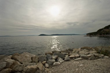 Bulutlu bir günde plaj ve deniz manzarası. Hırvatistan 'da Adriyatik Denizi Kıyısı.