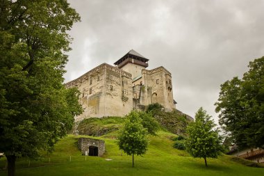 Slovakya 'da 11. yüzyıldan kalma antik Trencin Kalesi. Bir dağın tepesinde ortaçağ şatosu olan bir manzara..