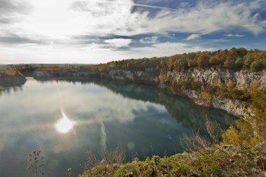 Sonbahar manzarası. Dik kıyıları ve güneşli bir sonbahar gününde sarı ağaçları olan bir göl..