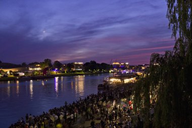 Nehirde renkli mavi gün batımı. Akşamları nehir kenarındaki şehir manzarası