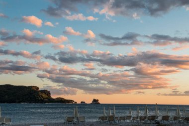 Budva 'da akşam kumsalı. Gün batımında Aziz Nicholas Adası