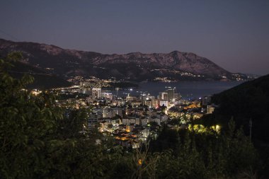 Karadağ 'da Budva. Dağdan, deniz kıyısındaki gece kasabasına bak.