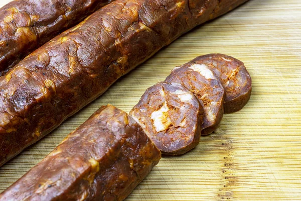 stock image Fresh homemade smoked sausage on a wooden table.