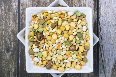 A colorful handful and brown lentils.